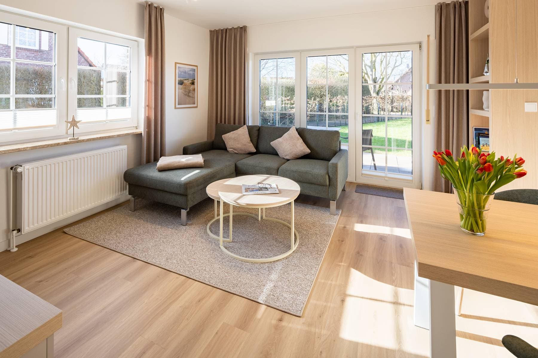 Ferienwohnung Riedgras 1 – Wohnbereich mit Sofa und Terrassentür