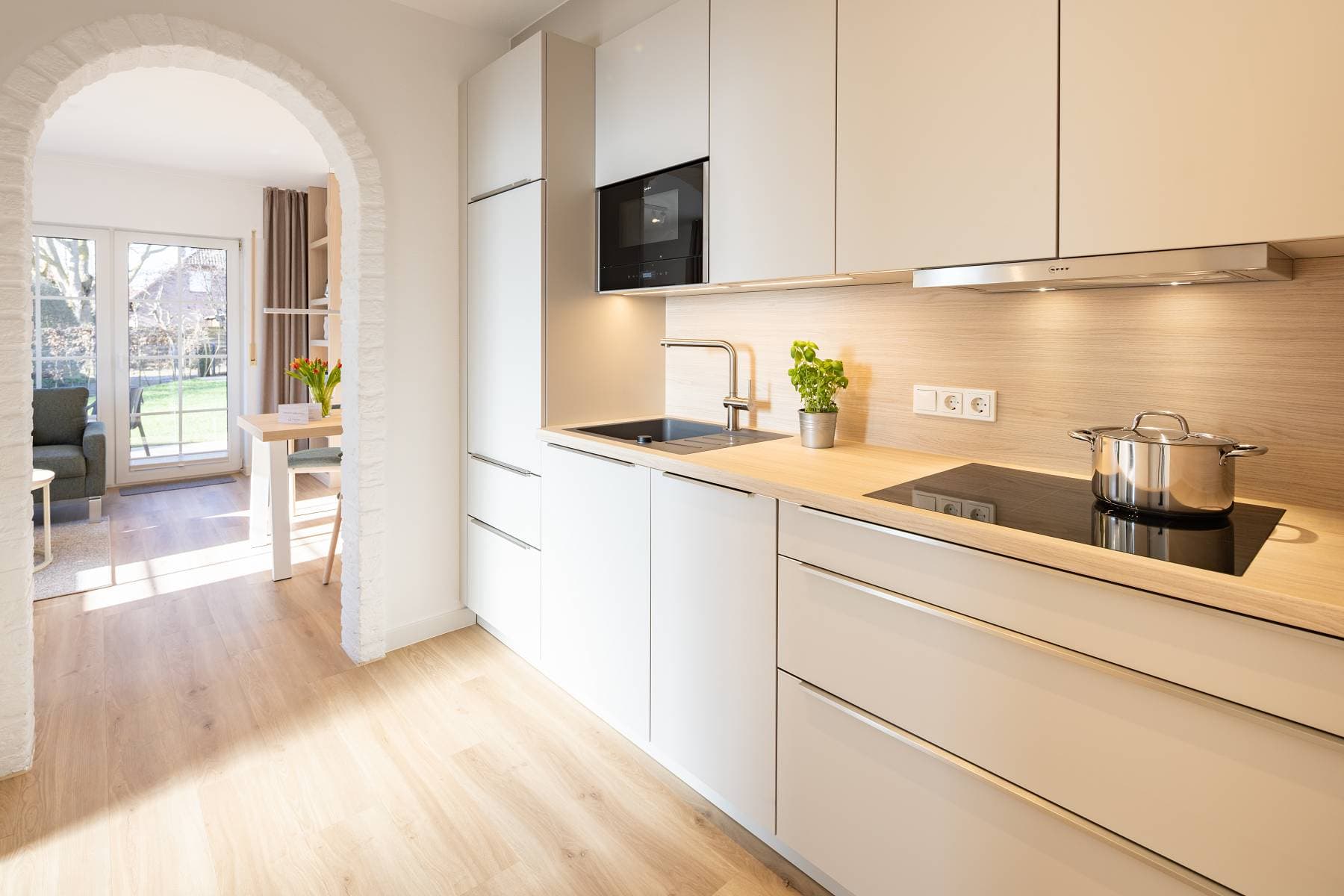 Ferienwohnung Riedgras 1 – Küchenzeile mit Induktionskochfeld und Blick in den Wohnbereich