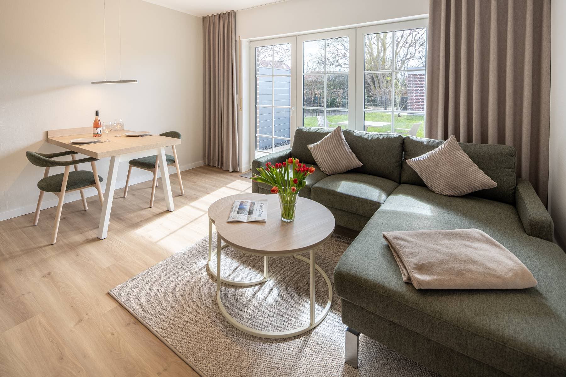Ferienwohnung Riedgras 2 – Wohnbereich mit Sofa und Blick in den Garten
