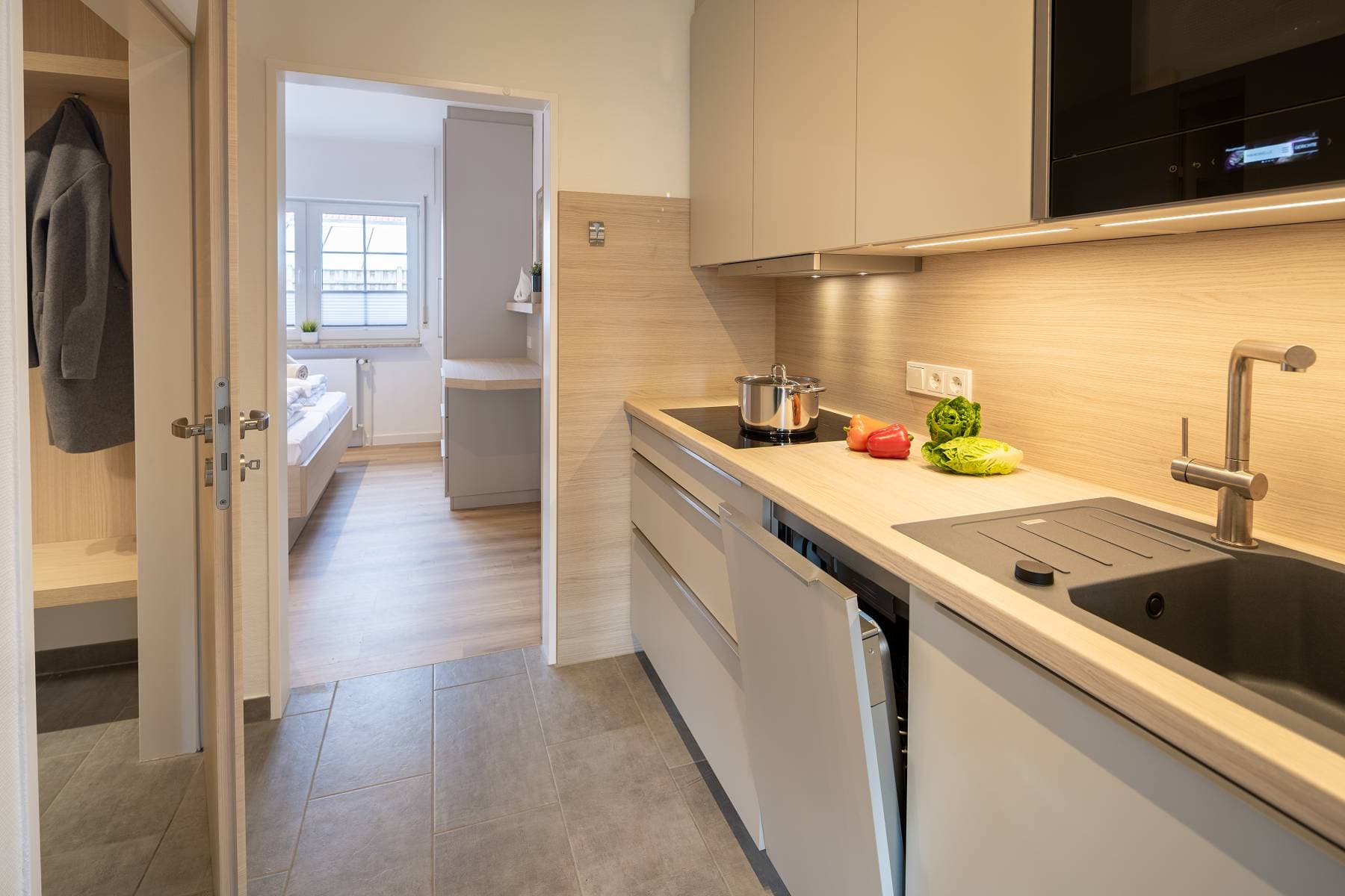 Ferienwohnung Riedgras 2 – Küchenzeile und Flur mit Blick ins Schlafzimmer