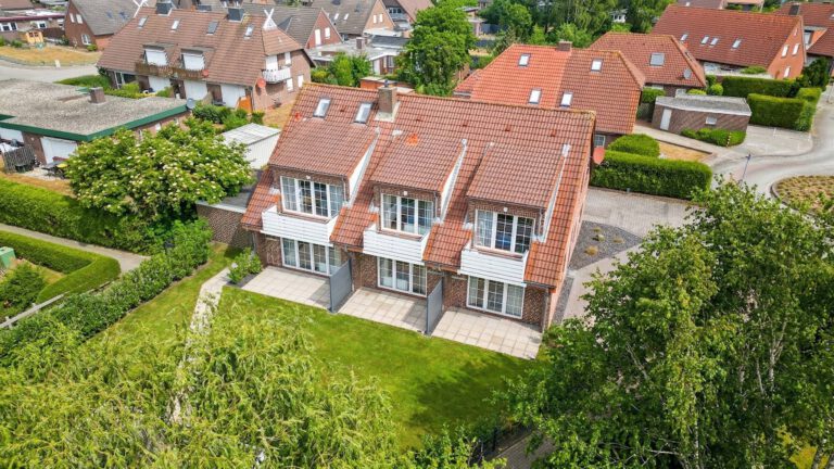 Luftaufnahme des Riedgrashauses in Norddeich mit Garten und Stellplaetzen